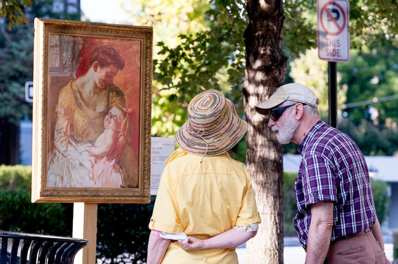 Passersby admire a serene Mary Cassatt painting in Louella Court. 
