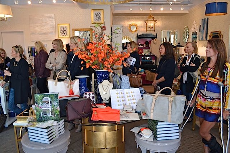 An invitation-only crowd listens as India Hicks describes her new lifestyle collection (displayed on the table in the foreground). 