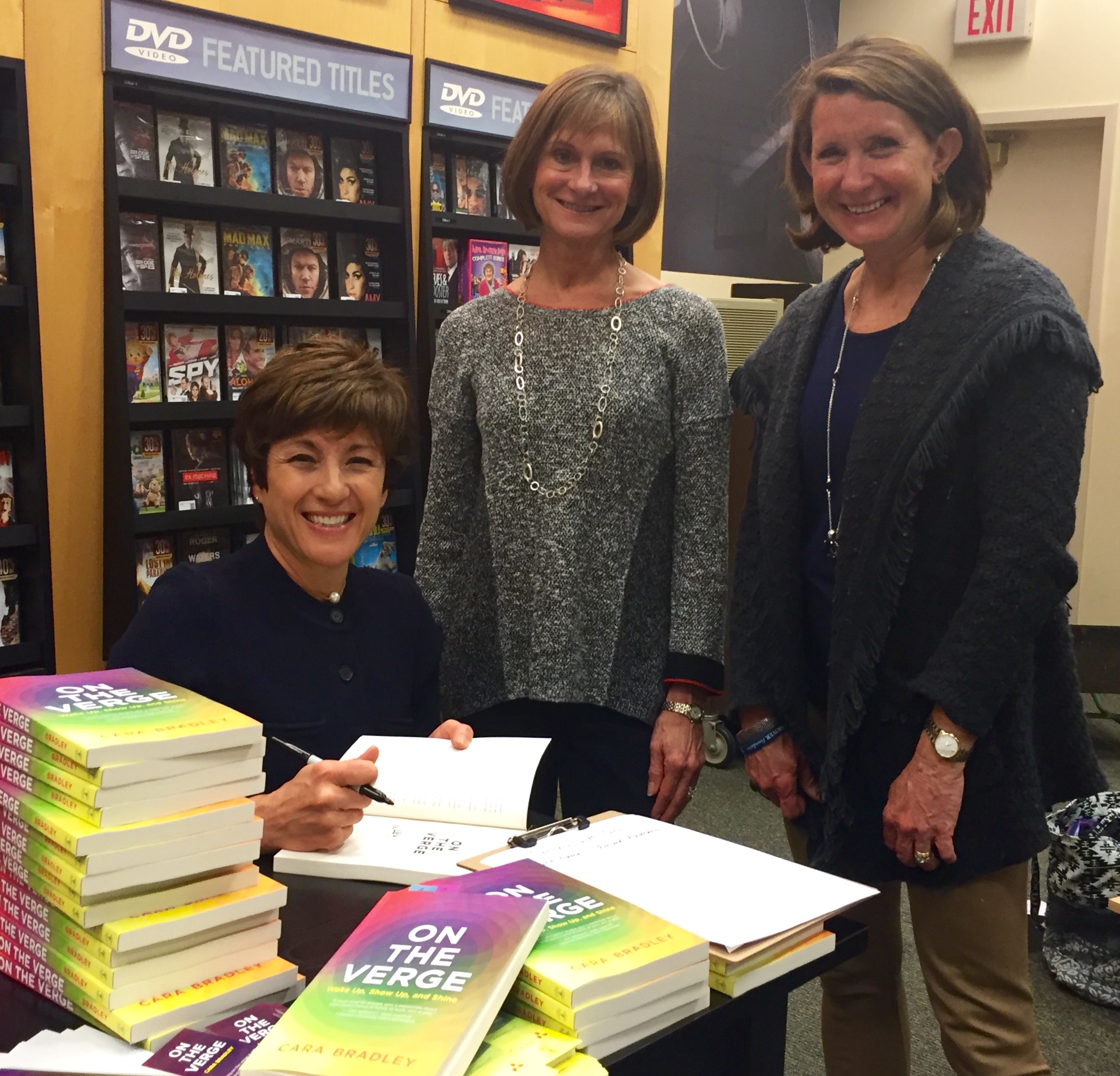 Author Cara Bradley signs books for Verge clients Allyson Hotz and Jean Kane. 