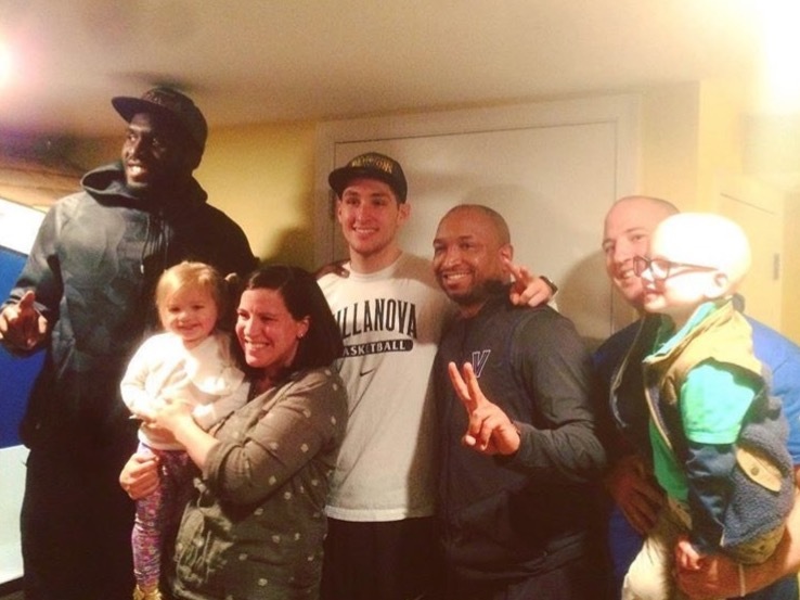 After the big surprise, Nova stars Daniel Ochefu and Ryan Archidiacono, Assistant Coach Ashley Howard pose with (from left) Lucy, 2, Annie, Andrew, and Blaise Davis, 4.