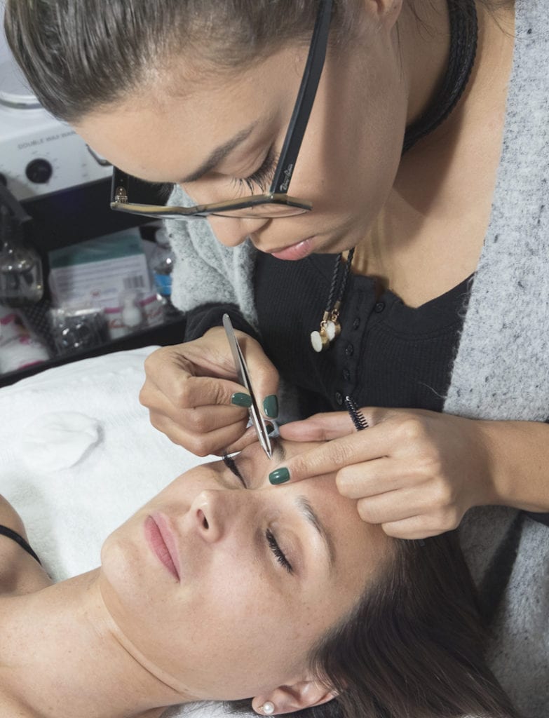 Marcel Dineen shapes a model's brows at her eponymous salon in Bryn Mawr.